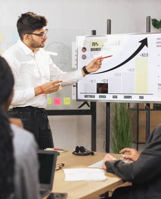 Team of diverse attentive mixed race business people listening their middle aged male indian chief Team of diverse attentive mixed race business people listening their middle aged male bearded indian chief showing dynamics of key ecological global problems or world market using digital wall screen